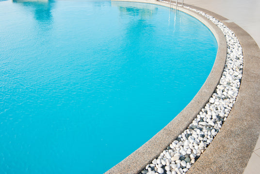 Pool mit Kieselsteinen am Rand.